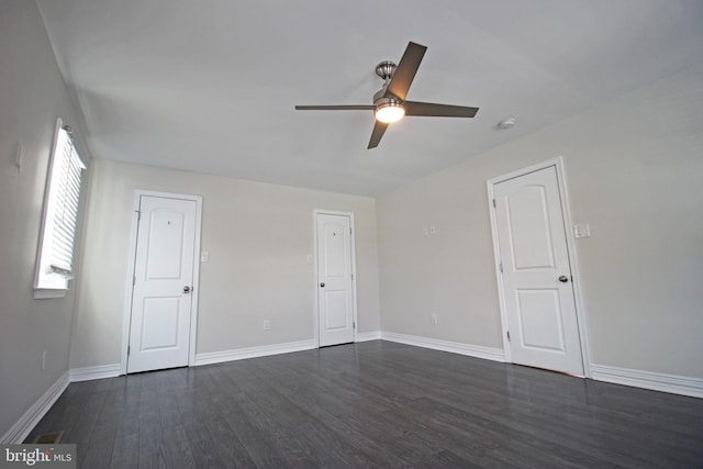 empty room with ceiling fan and dark wood-type flooring