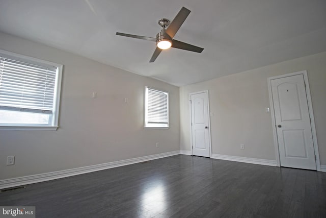 empty room with ceiling fan and dark hardwood / wood-style floors