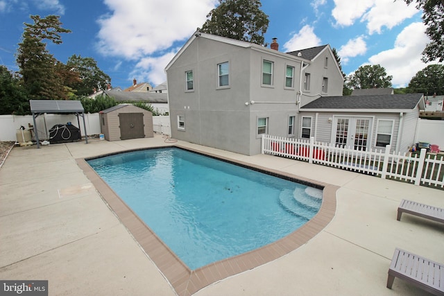 view of pool with a storage unit and a patio area