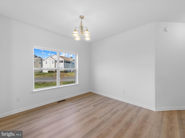 unfurnished dining area with a chandelier and light wood-type flooring