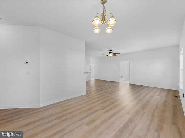 unfurnished living room featuring ceiling fan with notable chandelier and light hardwood / wood-style floors