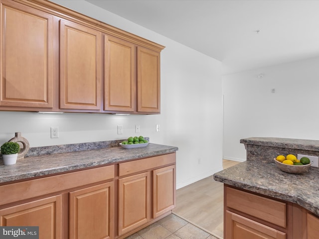 kitchen featuring dark stone counters and light hardwood / wood-style flooring