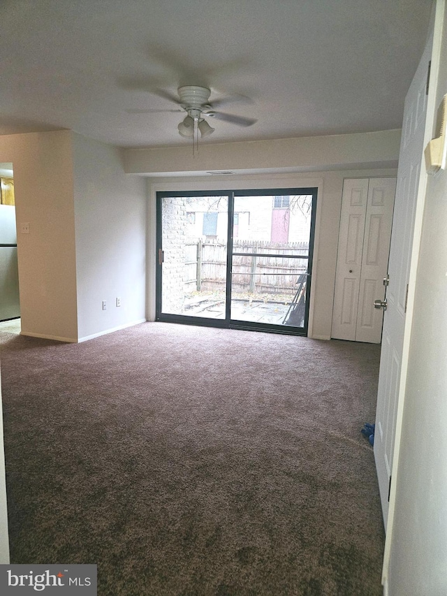 unfurnished room with ceiling fan and carpet