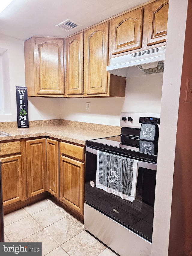 kitchen featuring stainless steel range with electric stovetop and light tile patterned flooring