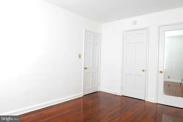 unfurnished bedroom with dark wood-type flooring