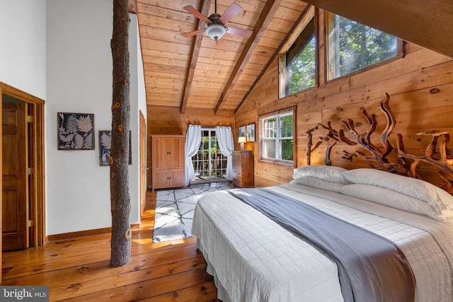 bedroom with beam ceiling, high vaulted ceiling, light hardwood / wood-style flooring, wooden ceiling, and wood walls