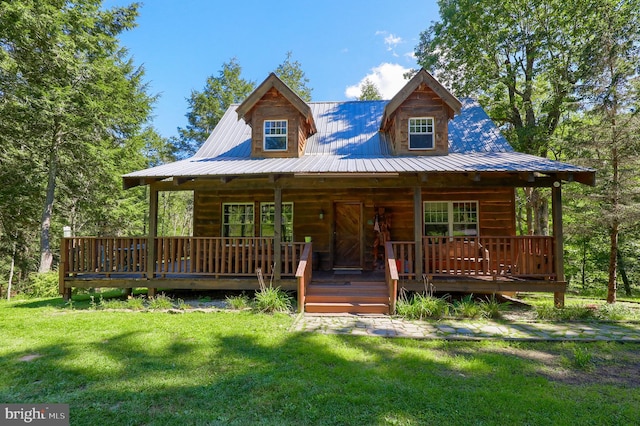 log home featuring covered porch and a front yard