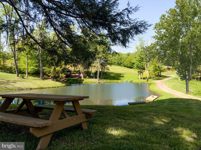 view of community with a lawn and a water view