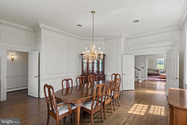 dining room with an inviting chandelier, dark hardwood / wood-style flooring, crown molding, and a baseboard heating unit