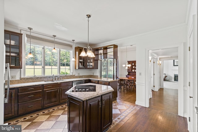 kitchen with pendant lighting, a center island, sink, light wood-type flooring, and dark brown cabinetry