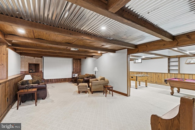 carpeted cinema room with beamed ceiling, wooden walls, and billiards