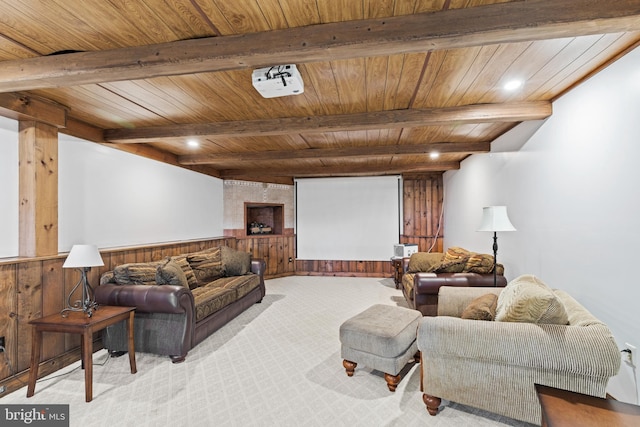 carpeted cinema room featuring wood walls, beamed ceiling, and wood ceiling