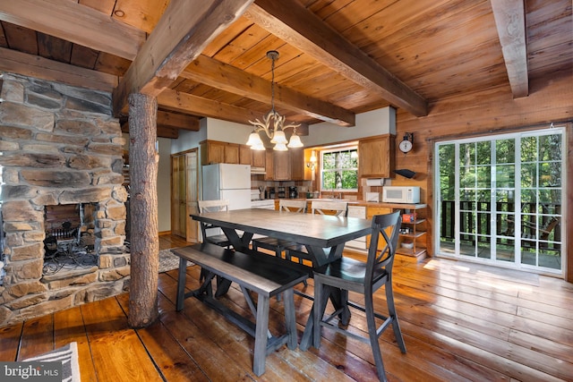 dining area featuring beamed ceiling, light wood-type flooring, an inviting chandelier, and wood ceiling