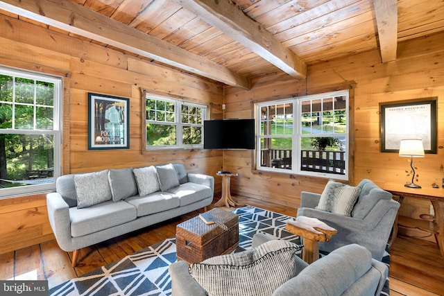 living room featuring beam ceiling, hardwood / wood-style flooring, wooden walls, and wood ceiling