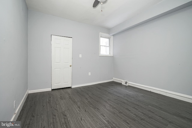 empty room featuring ceiling fan and dark wood-type flooring