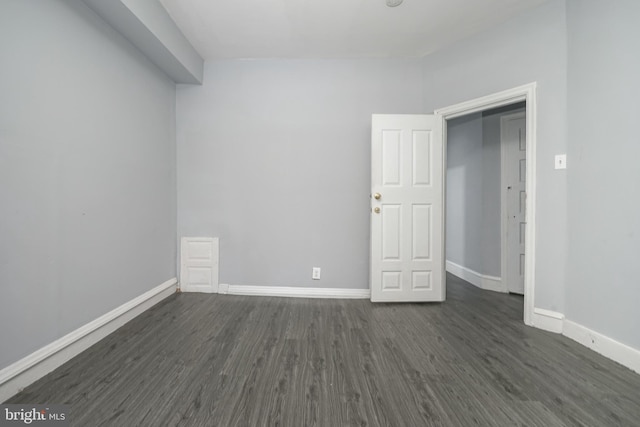 unfurnished room with dark hardwood / wood-style flooring