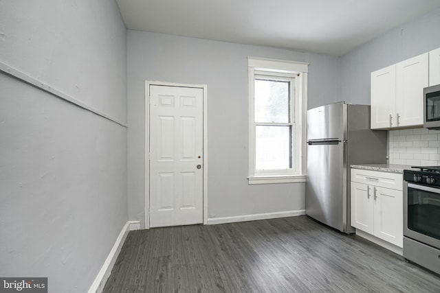 kitchen featuring tasteful backsplash, white cabinets, stainless steel appliances, and dark hardwood / wood-style floors