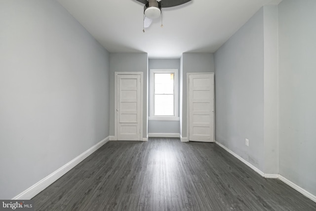 unfurnished bedroom with ceiling fan and dark wood-type flooring