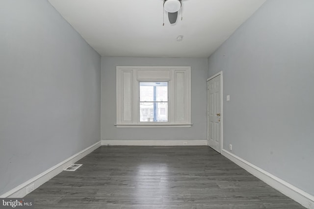 spare room featuring ceiling fan and dark wood-type flooring