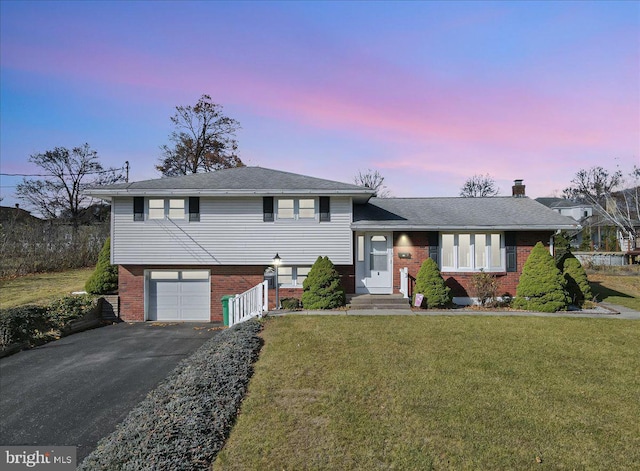 tri-level home with a garage and a yard