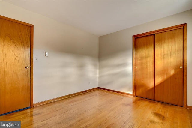 unfurnished bedroom with a closet and light hardwood / wood-style flooring