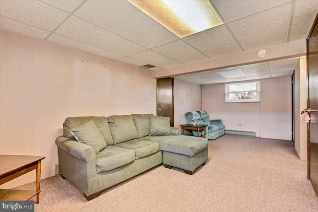 living room with a drop ceiling, light carpet, and a baseboard heating unit