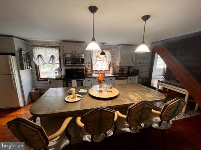 dining room with brick wall and light wood-type flooring