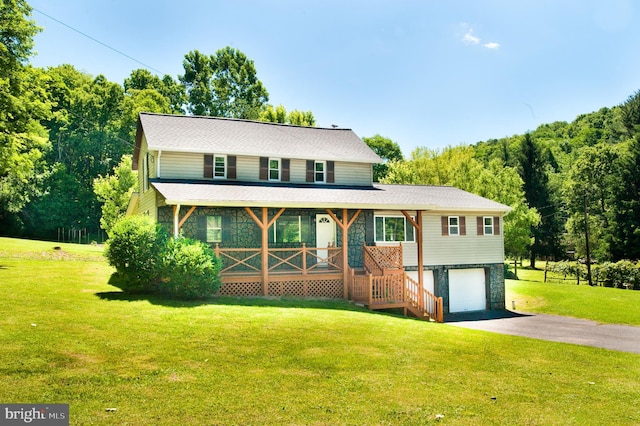 view of front facade featuring a porch, a garage, and a front yard