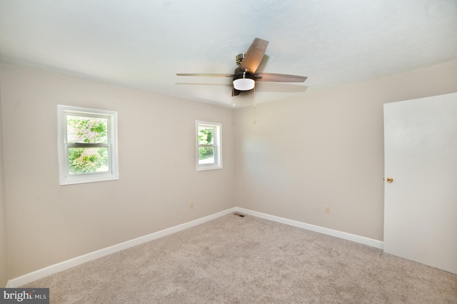 unfurnished room with carpet flooring, ceiling fan, and a healthy amount of sunlight