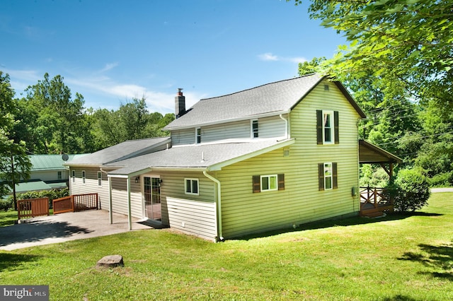 rear view of house featuring a lawn and a patio