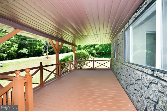 wooden deck with a porch and a lawn