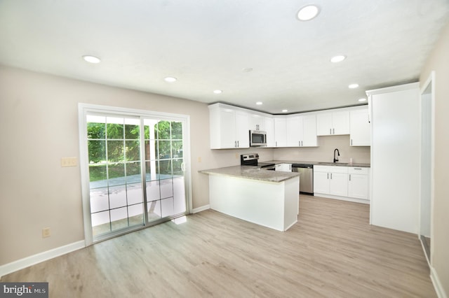 kitchen featuring kitchen peninsula, light wood-type flooring, stainless steel appliances, and white cabinetry