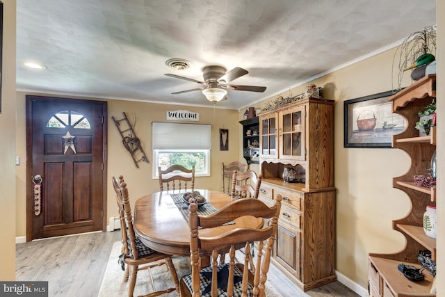 dining space with light hardwood / wood-style flooring, ceiling fan, and ornamental molding