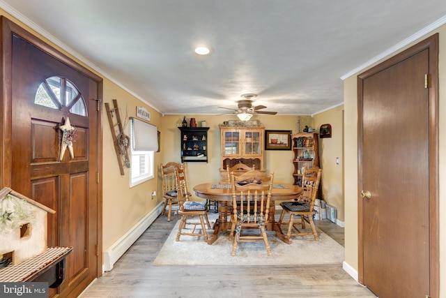 dining room featuring wood-type flooring, a wealth of natural light, and crown molding