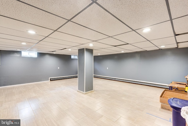 basement with baseboard heating and a drop ceiling