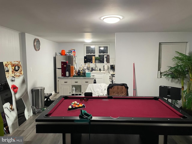 game room featuring light hardwood / wood-style floors, indoor wet bar, and pool table