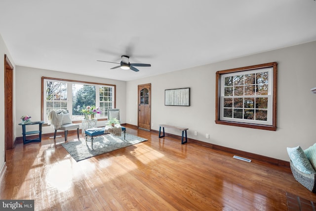 living room featuring hardwood / wood-style floors and ceiling fan