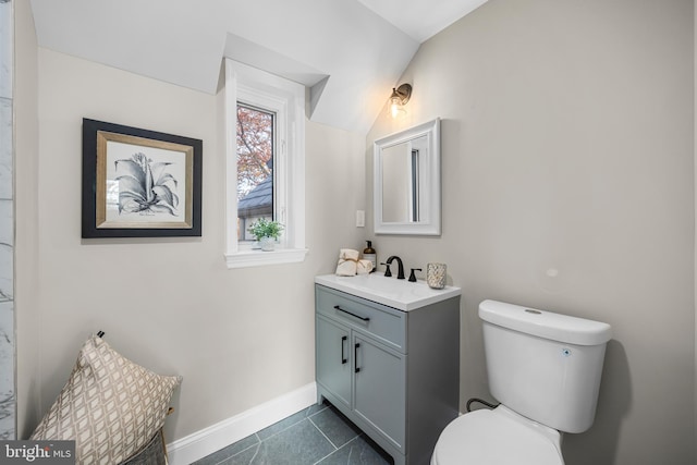 bathroom with tile patterned floors, vanity, lofted ceiling, and toilet