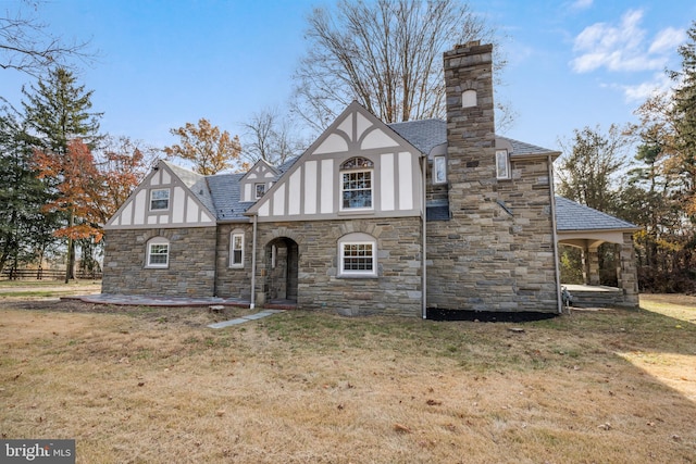 tudor home with a front lawn