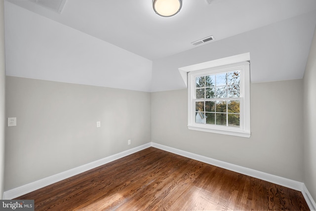 additional living space with hardwood / wood-style flooring and lofted ceiling