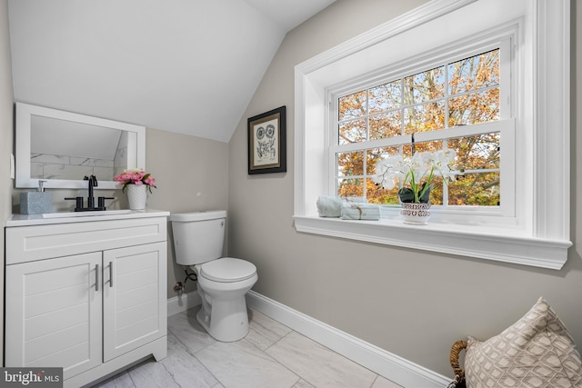 bathroom featuring vanity, toilet, and lofted ceiling