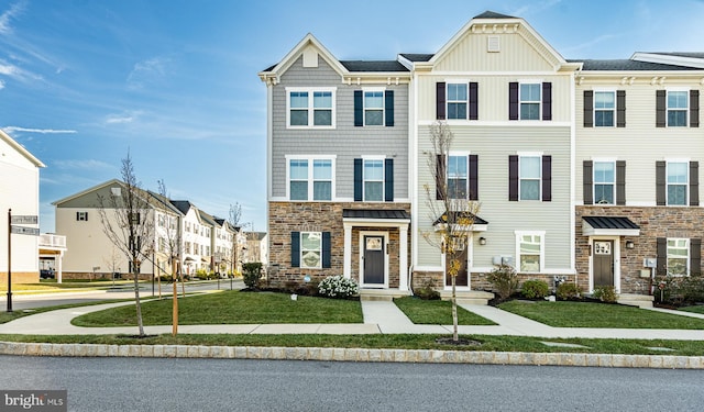 townhome / multi-family property featuring a front lawn