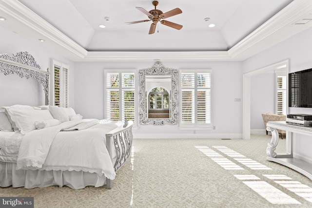 bedroom with ceiling fan, crown molding, light carpet, and a tray ceiling