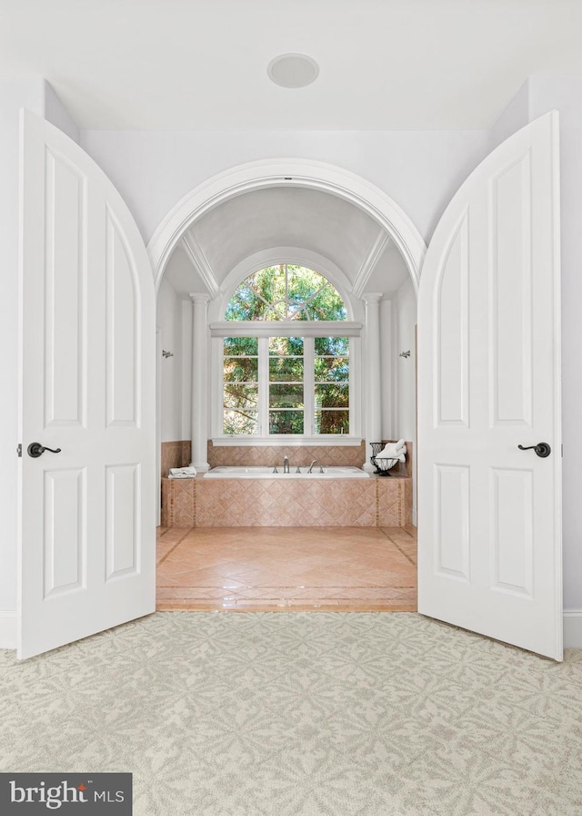 bathroom featuring a bathing tub and lofted ceiling