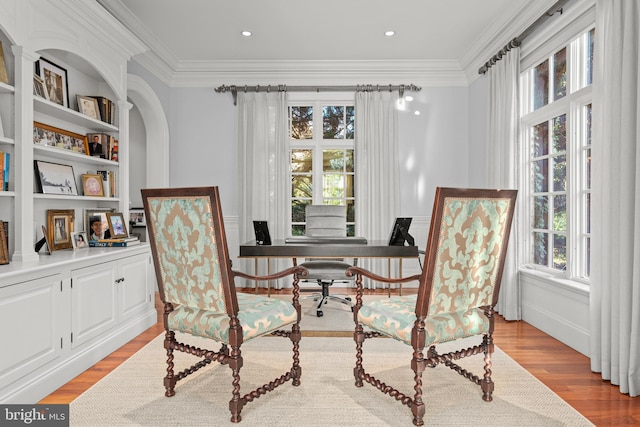 sitting room with light wood-type flooring and crown molding