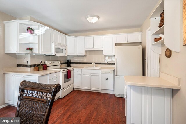 kitchen featuring decorative backsplash, white cabinetry, white appliances, and dark wood-type flooring