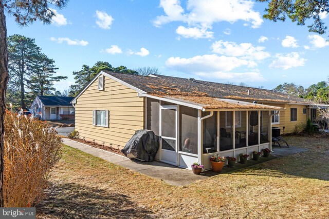 back of house with a sunroom and a yard