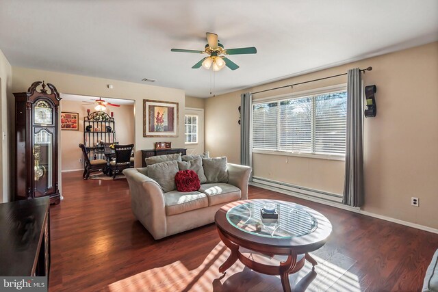 living room featuring a baseboard heating unit, ceiling fan, and dark wood-type flooring