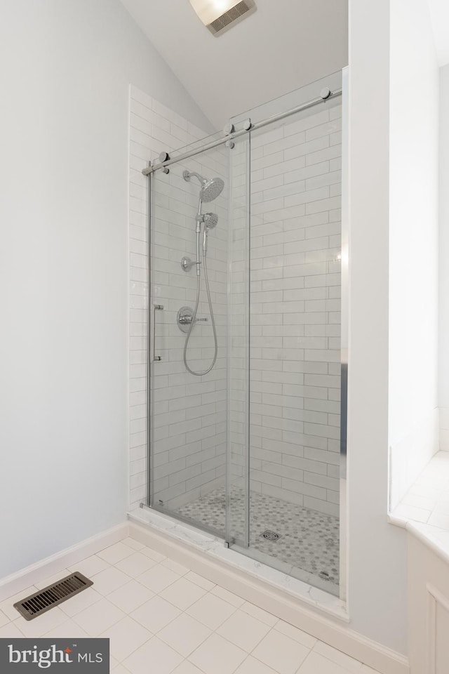 full bathroom with vaulted ceiling, baseboards, a shower stall, and visible vents