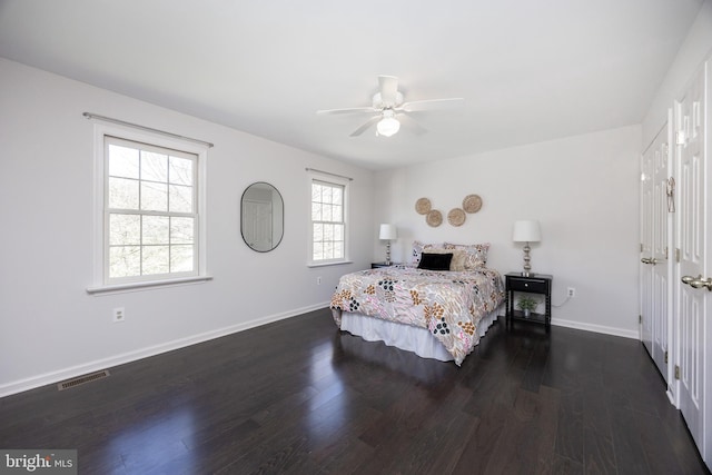 bedroom featuring baseboards, a ceiling fan, wood finished floors, and visible vents